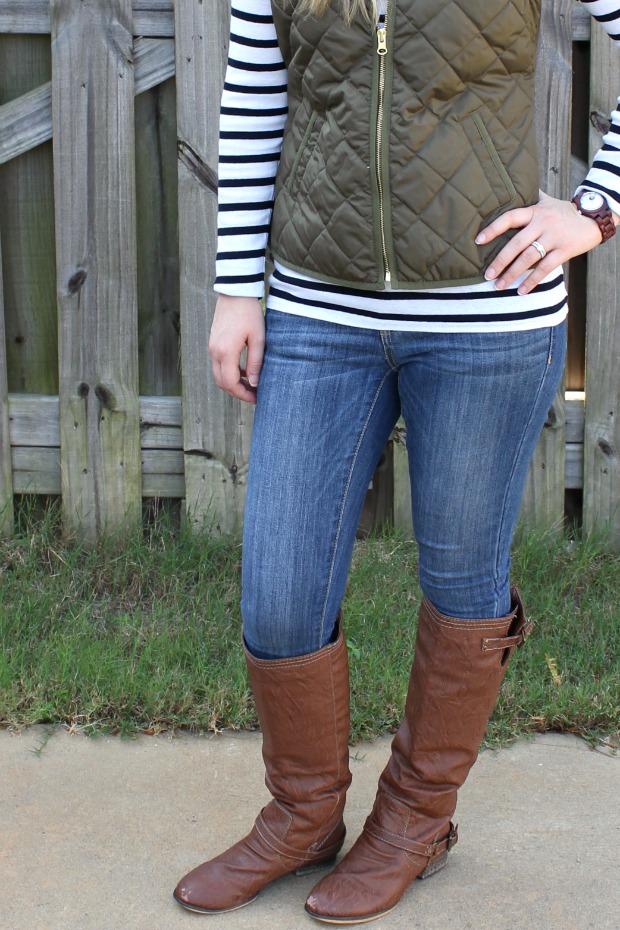 Woman in cognac riding boots, skinny jeans, striped top and olive quilted vest