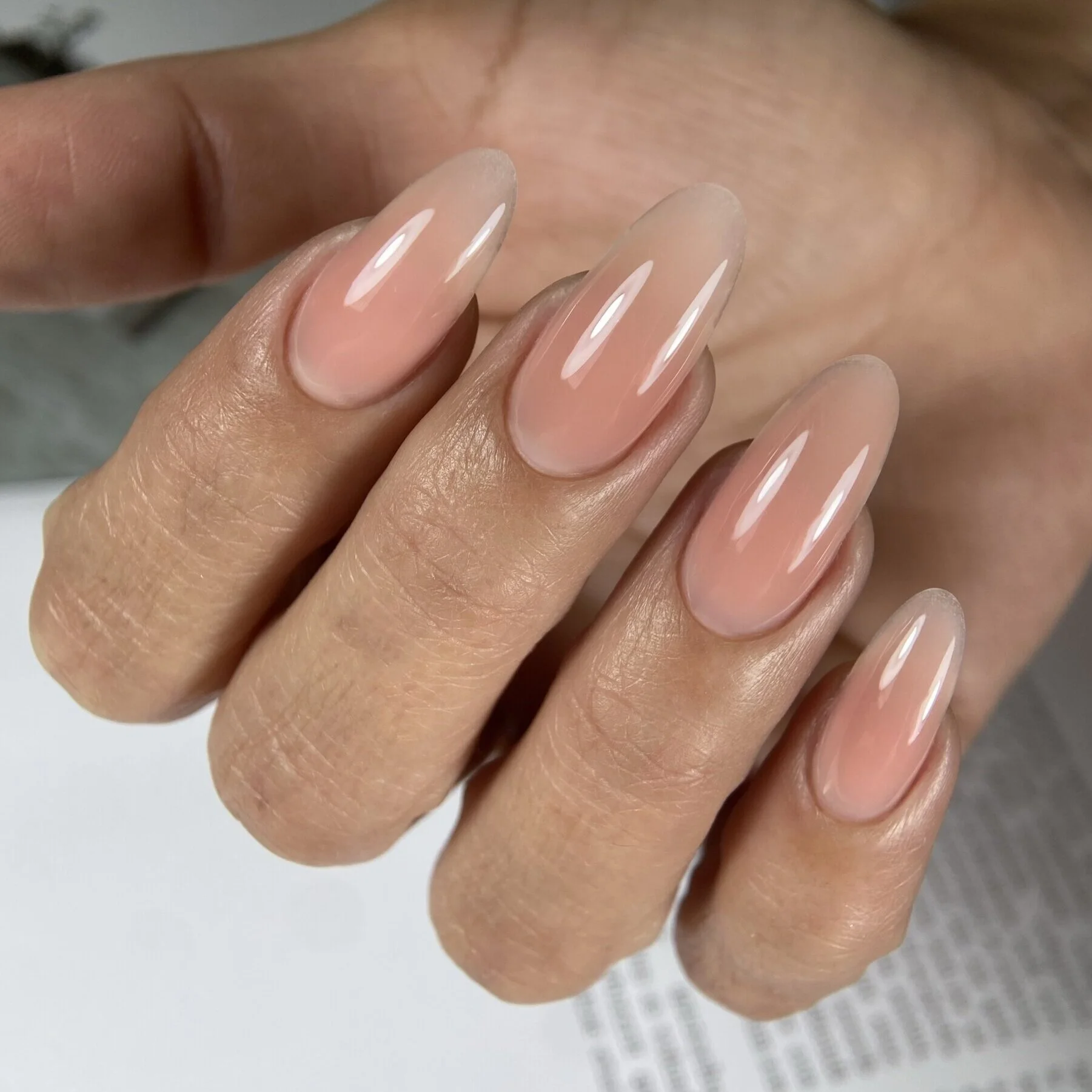 Sheer nude almond nails with glass-like finish