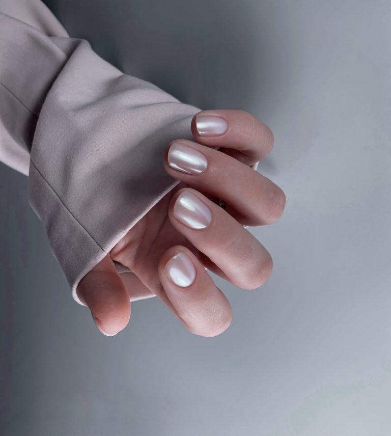Short oval nails in white with a pearly chrome shimmer finish.