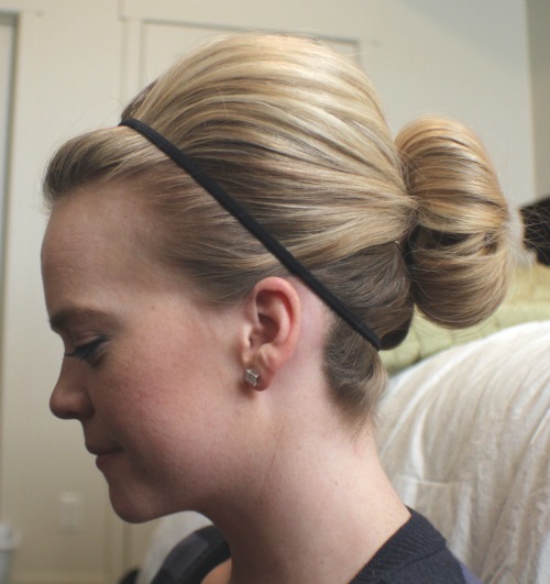 Side profile of a high sock bun worn with a thin black headband