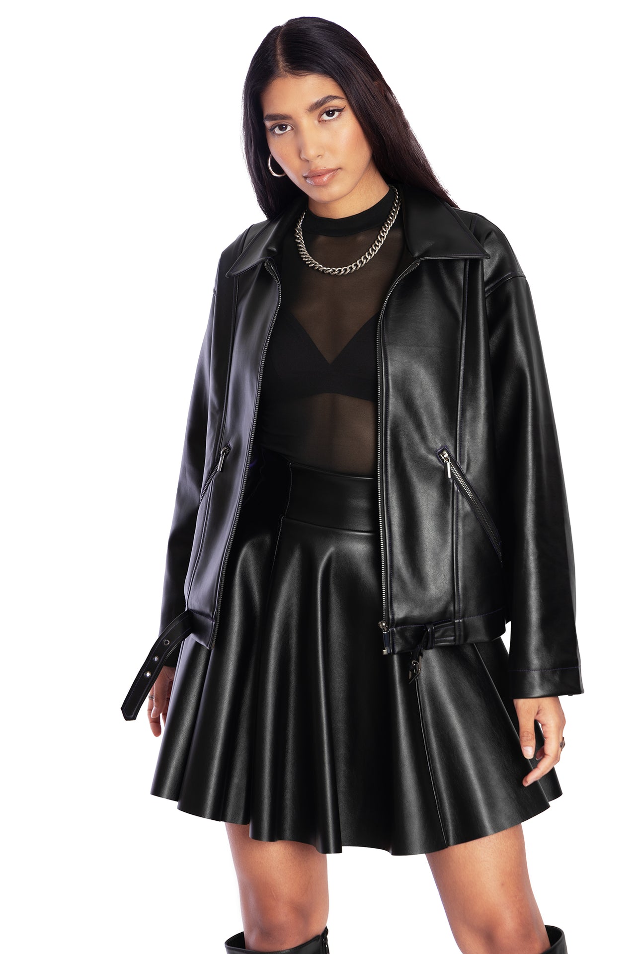 Model in black leather moto jacket with black leather skater skirt and mesh top