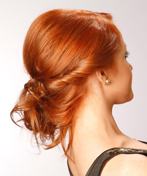 Copper-red hair with a braided wrap into a low knot bun, real salon photograph.