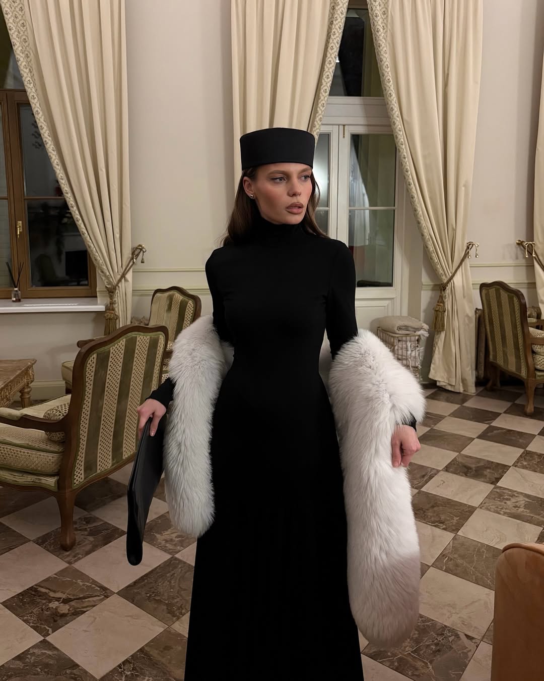 Black turtleneck maxi dress with white faux fur stole and black pillbox hat