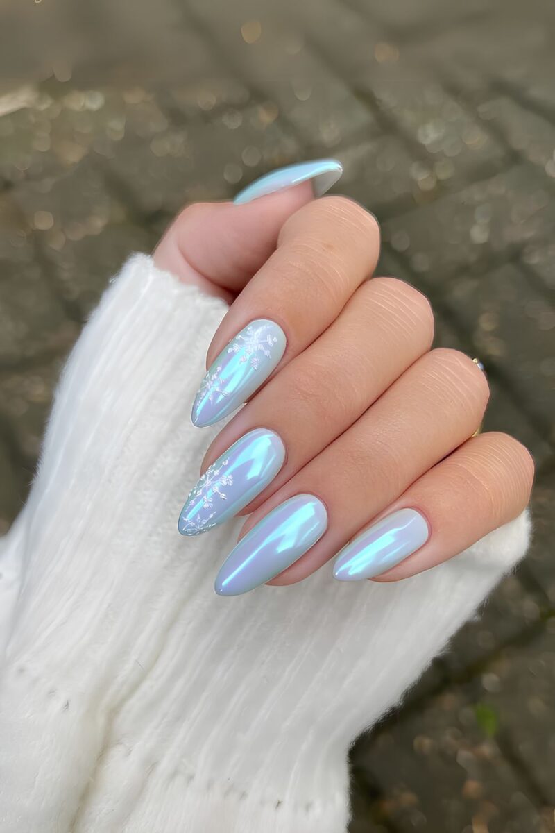 Almond nails in pastel blue chrome with white snowflake nail art