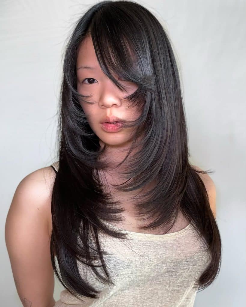 Glossy black long layered hair with curtain bangs