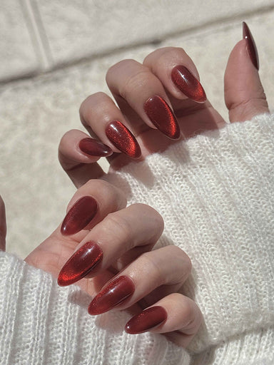 Magnetic velvet red gel nails with a plush cat-eye finish