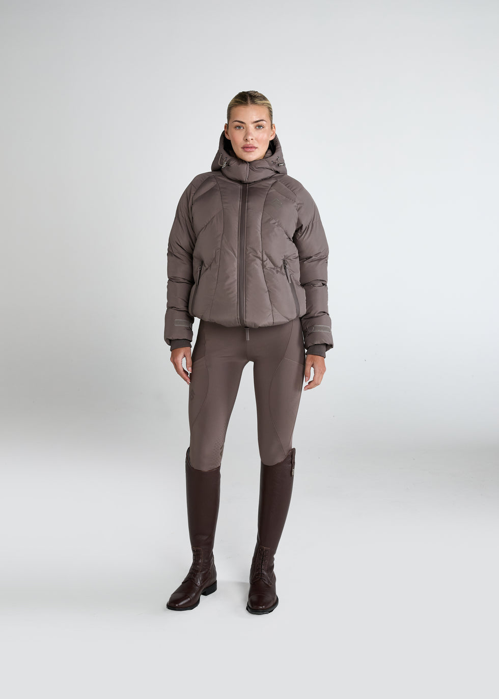 Dark brown lace-up riding boots with riding leggings and a puffer jacket