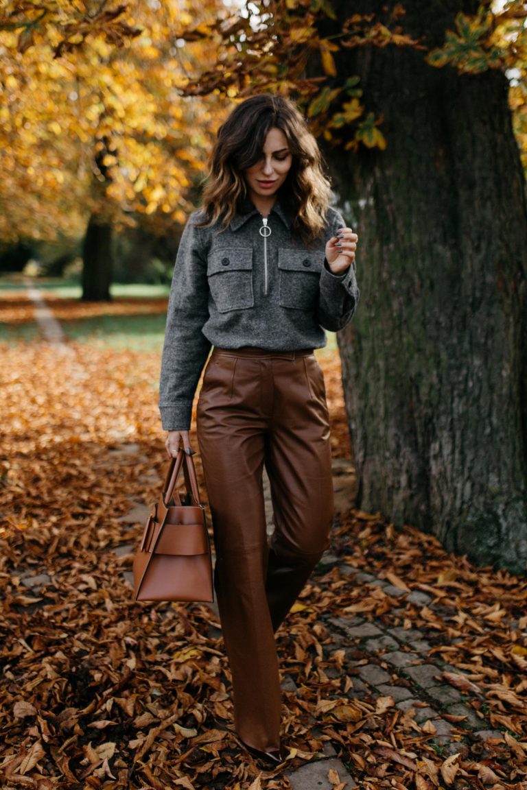 Fashion blogger wearing chocolate brown leather trousers with a fine knit sweater in a fall outfit