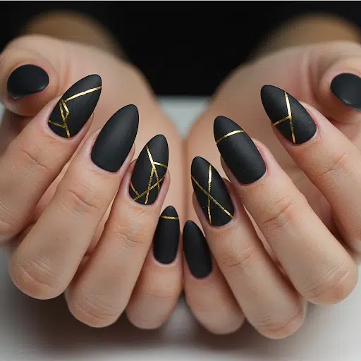 Matte black almond nails with thin gold geometric lines