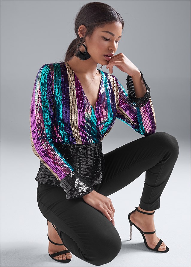 Woman styling a metallic gold top with dark jeans