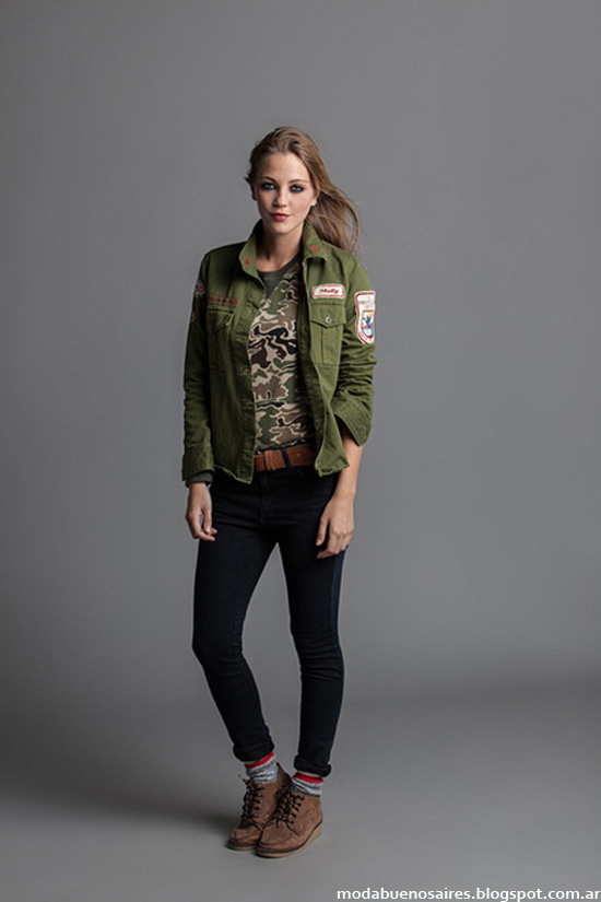 Woman in brown lace-up combat boots, black skinny jeans, a camouflage t-shirt and an olive military jacket with patches