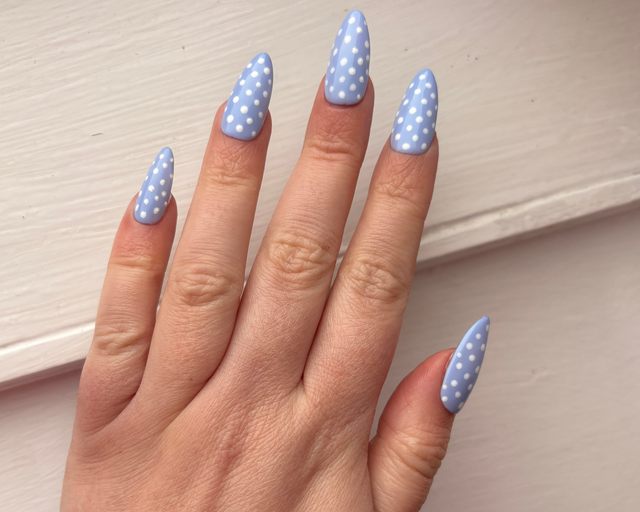 Almond nails in light blue with small white dot nail art