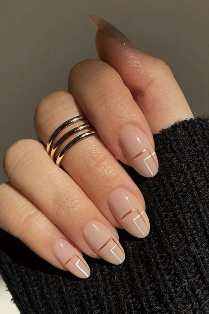 Nude almond nails with geometric white and gold line art designs