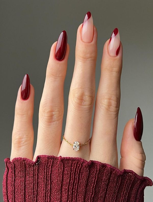 Almond nails mixing solid black cherry with nude and red French tips