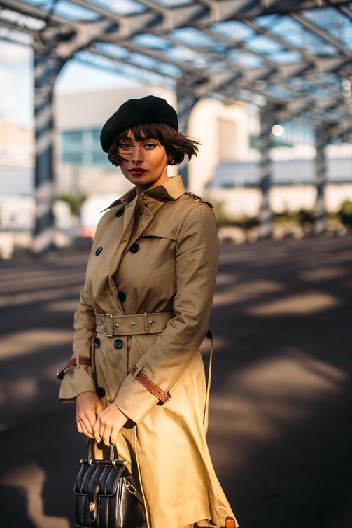 Street style photo of a woman wearing a beret with a trench coat in New York