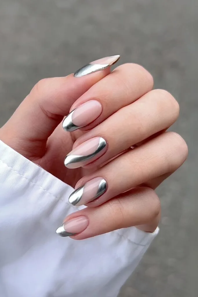 Nude French base nails with silver chrome swirls