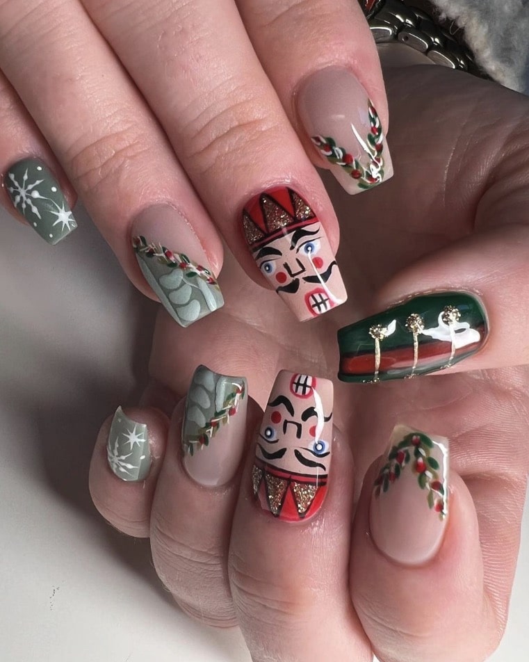 Nutcracker-inspired nail art: painted nutcracker soldier faces, red black and gold uniform details
