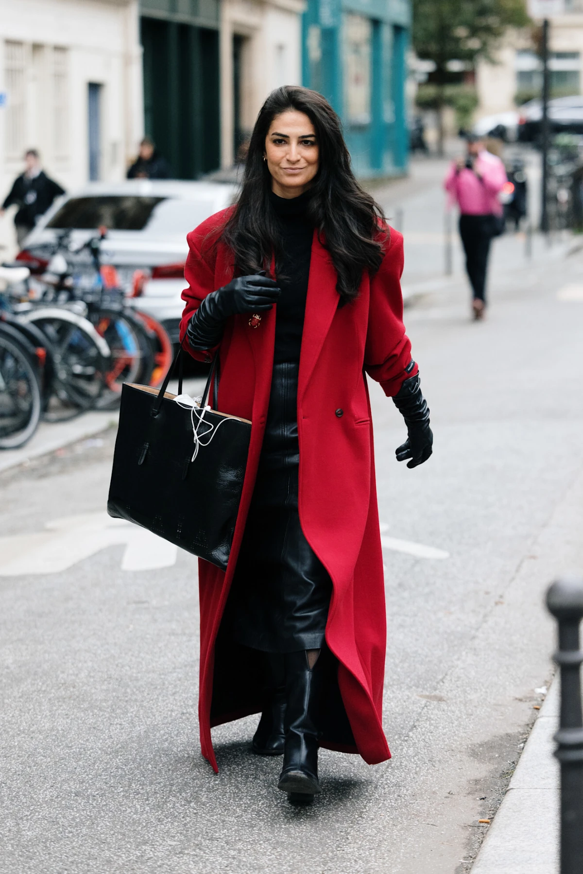 Woman in a red car coat with black layers in a street-style look