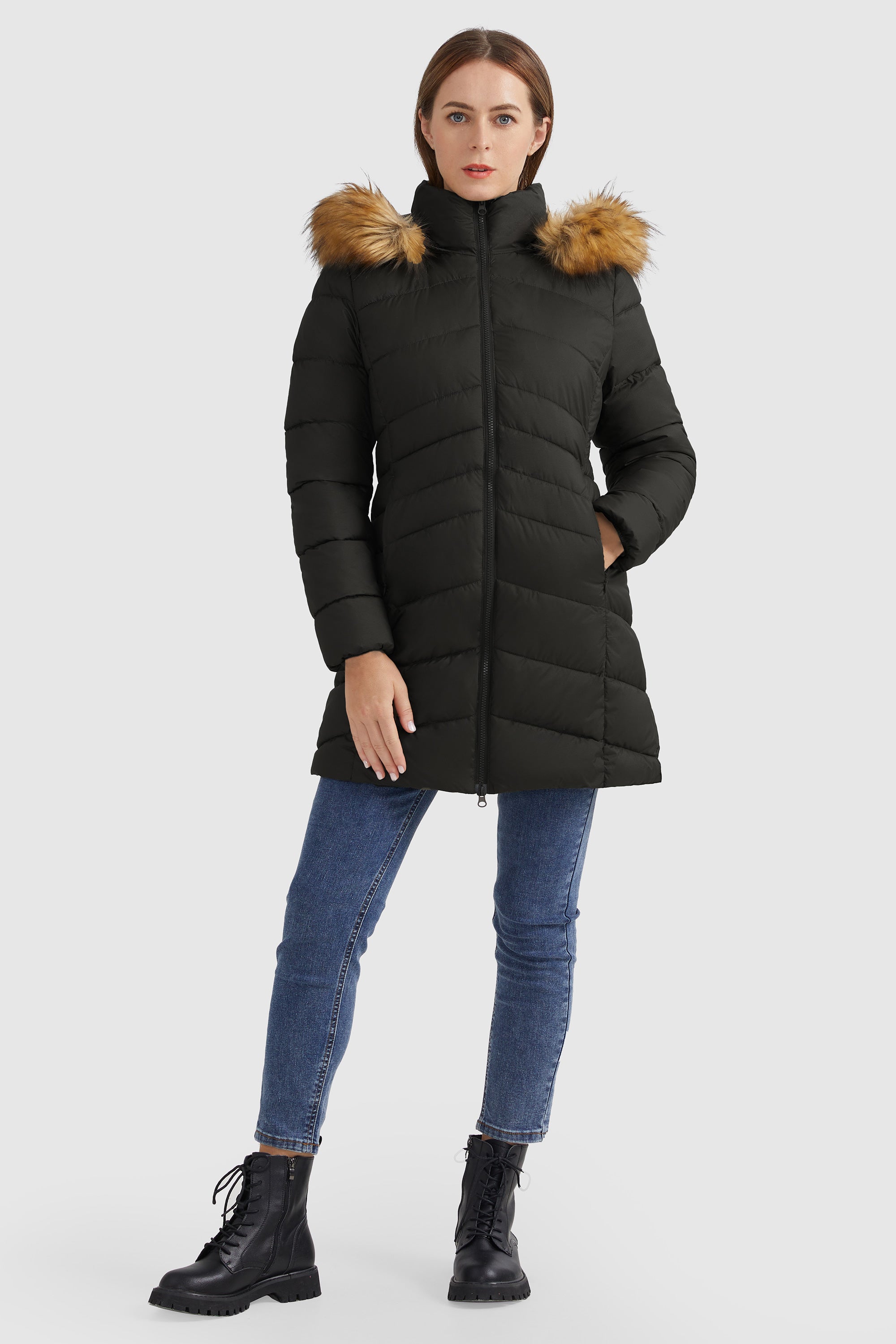 Model wearing a black quilted hooded parka with faux-fur trim, skinny jeans and black combat boots