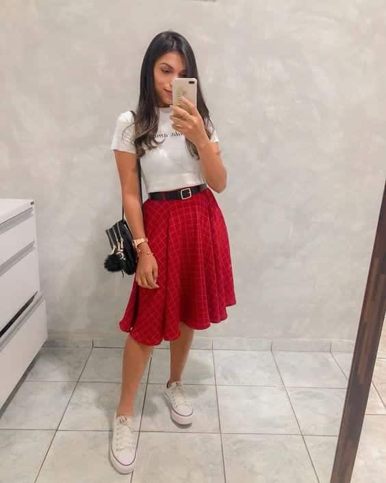 White tee tucked into a red plaid circle skirt with a belt
