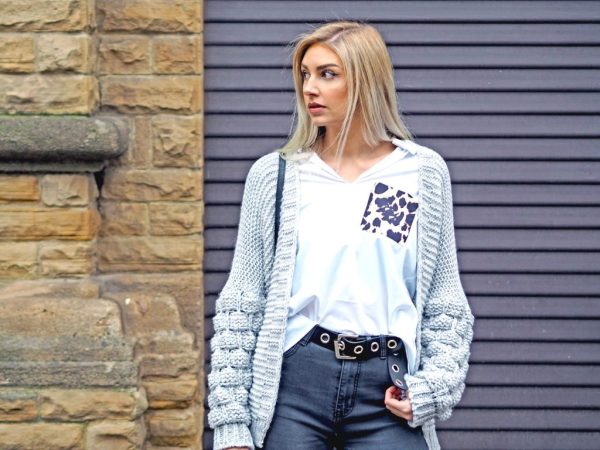 Woman in a chunky knit cardigan in a cozy indoor setting