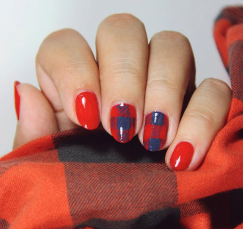 Short nails in glossy red with red and navy plaid accent nails