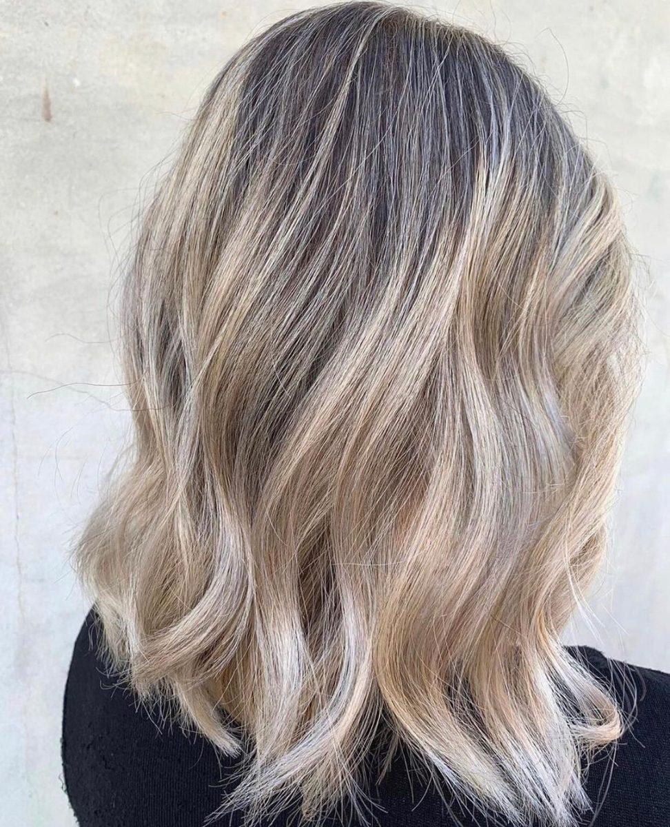 Sandy beige balayage with a smudged root on mid-back hair
