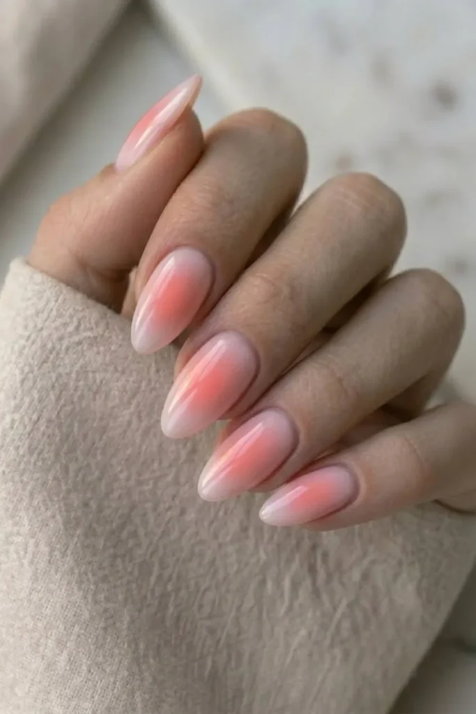 Almond nails with a pink aura blush gradient over milky white