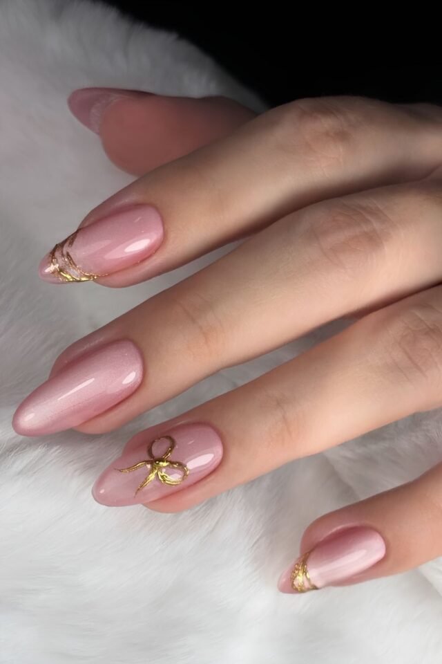 Pink cat-eye magnetic nails with small gold bow accents