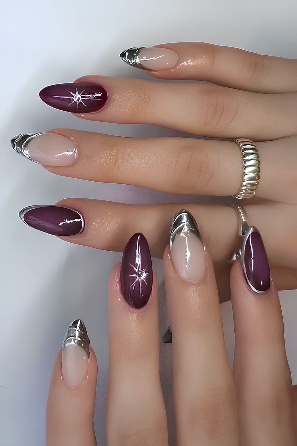 Plum nails with silver chrome French tips and starburst art