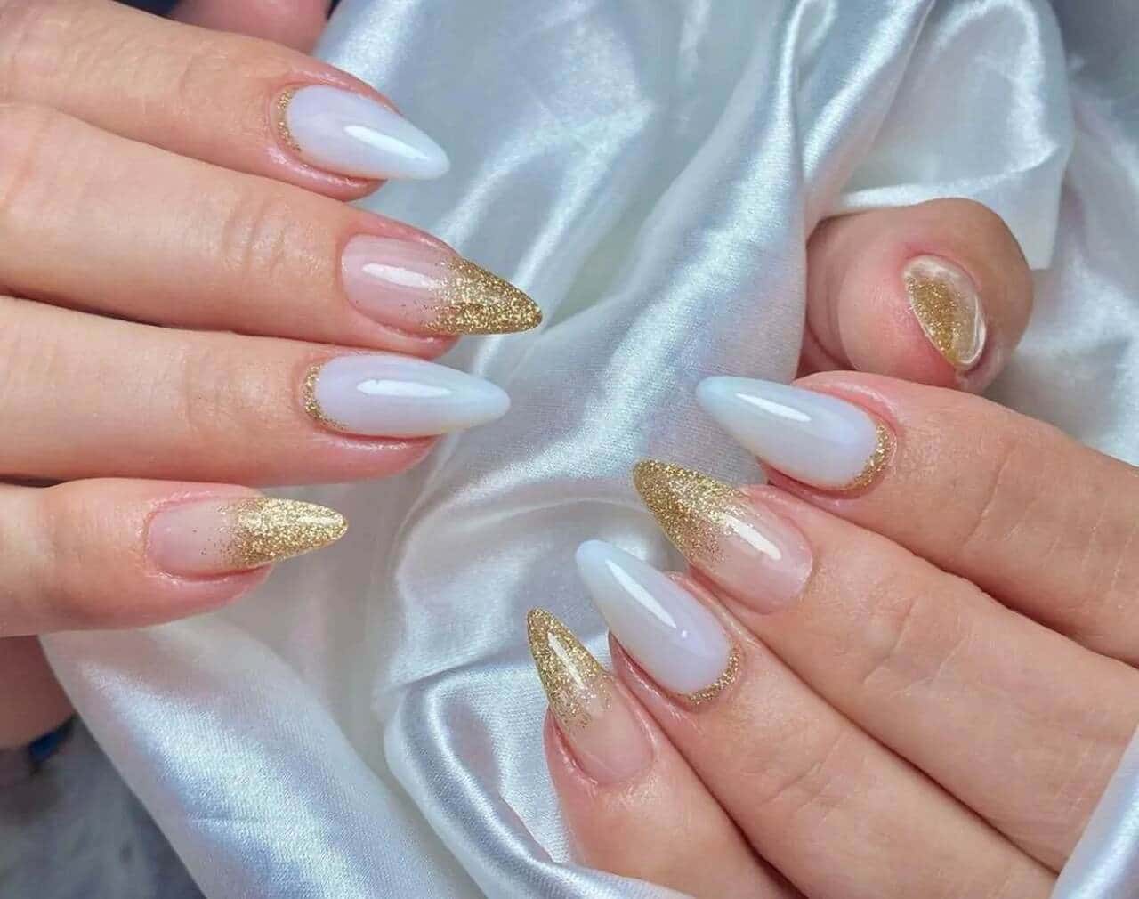 Milky White with Gold Glitter Tips: almond nails in milky white with gold glitter tips and cuticle lines