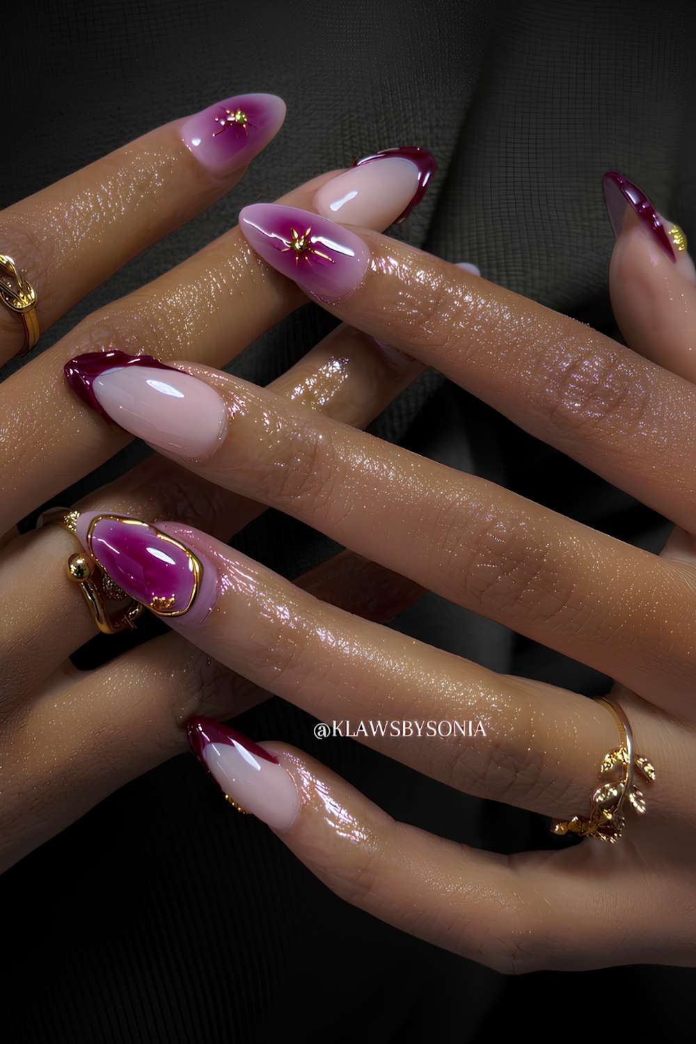 Long almond nails with purple magenta aura gradients, gold starburst art, and purple French tip accents