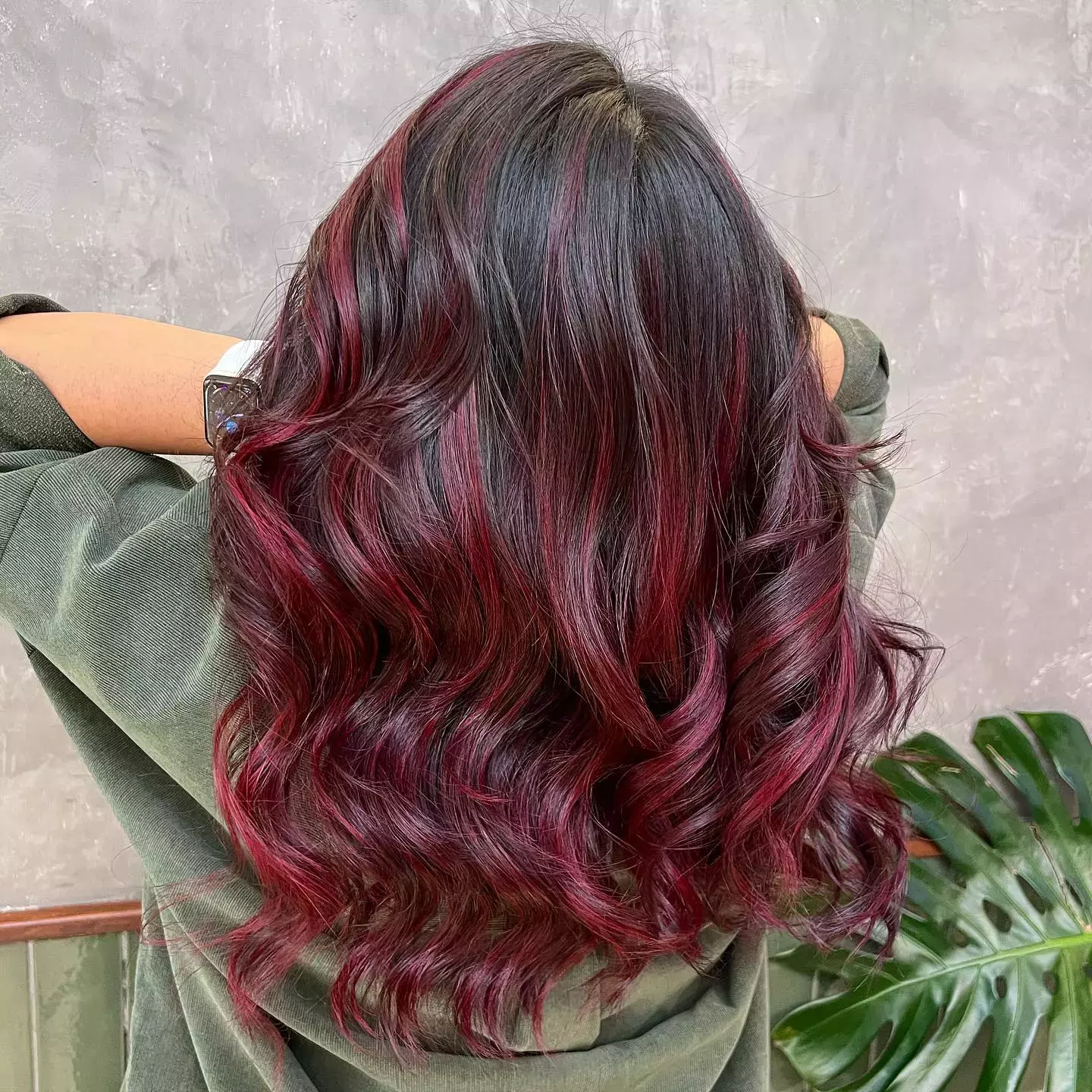 Back view of long wavy hair with radiant mahogany balayage highlights
