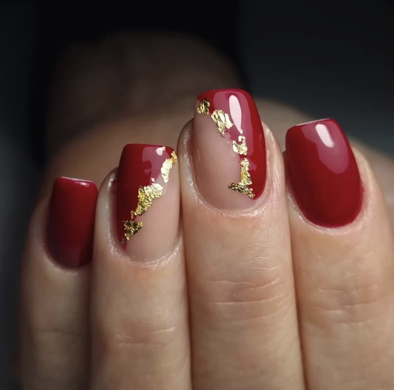 Red nails with gold foil accents