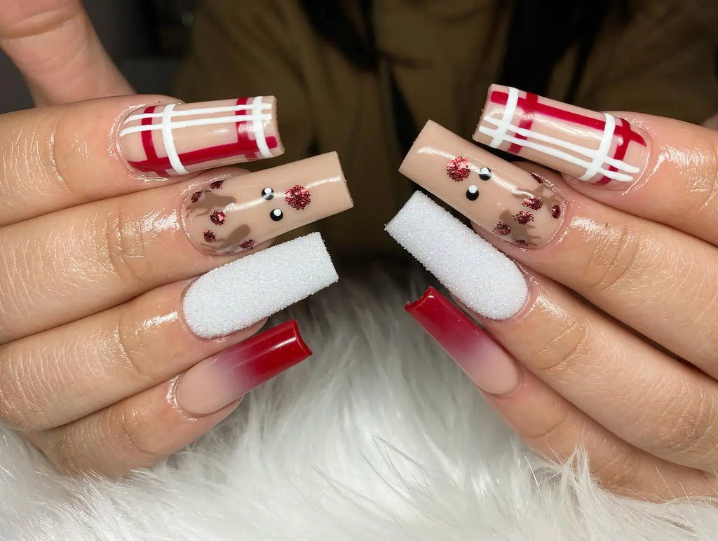 Close-up of square acrylic nails: red-and-white buffalo plaid nail art paired with reindeer face nail art with a glittery red nose