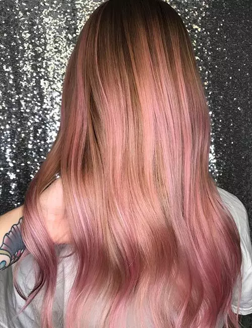 Back view of long wavy hair with rose-brown roots melting to soft rose-gold pink ends