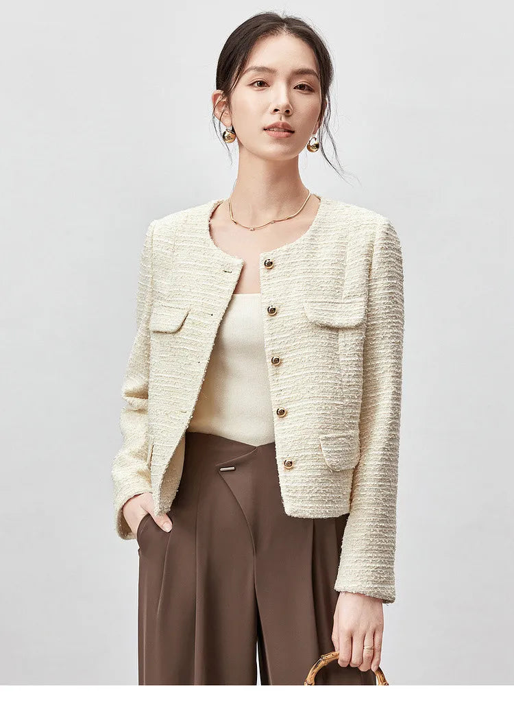 Woman wearing a cream tweed jacket over a cream knit top with brown wide-leg trousers
