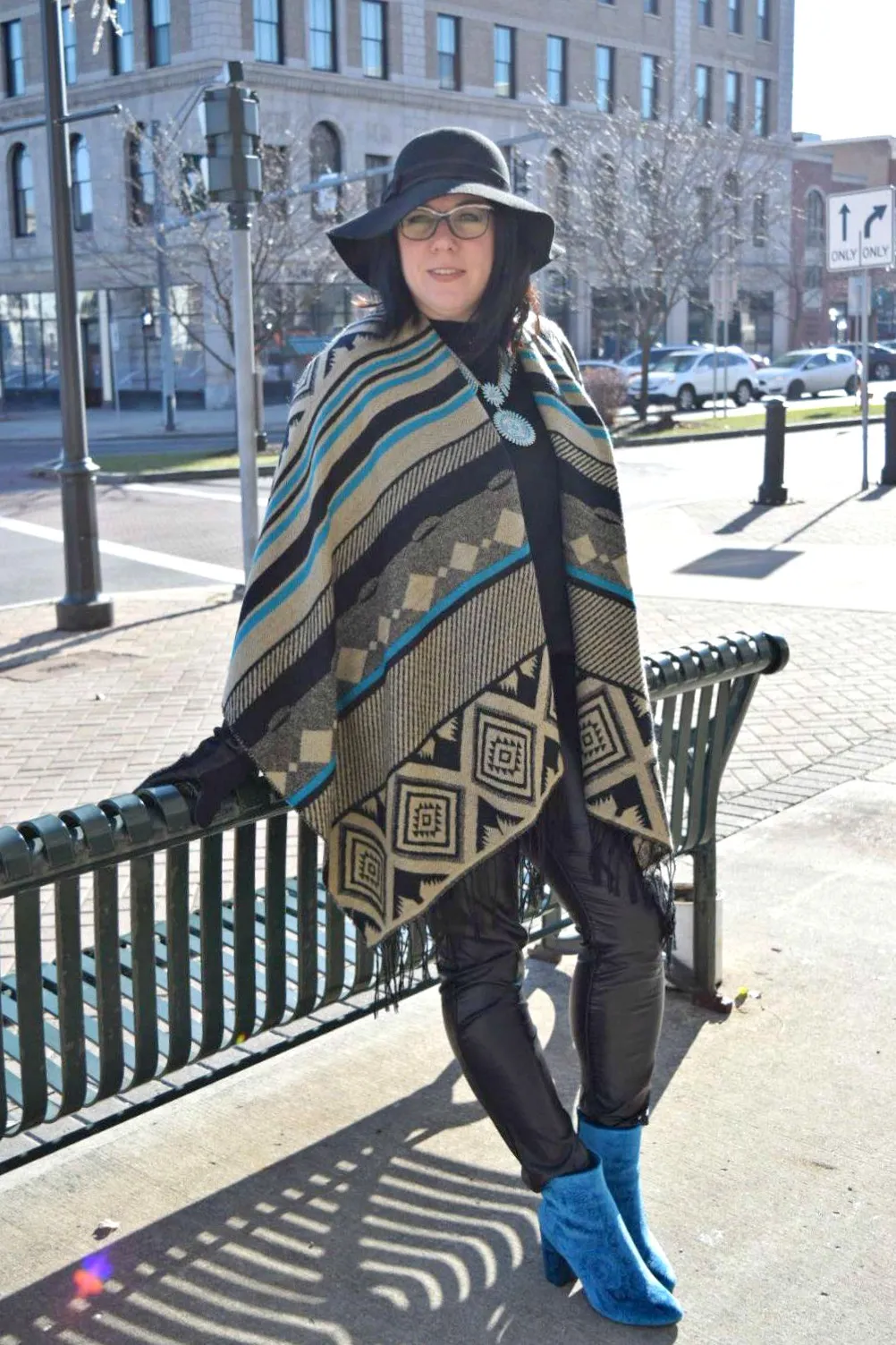 Woman wearing a crochet poncho with leggings and suede boots