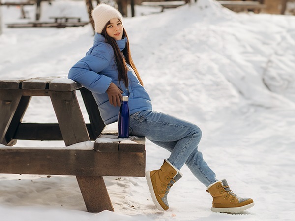Woman wearing snow boots with skinny jeans and a winter coat