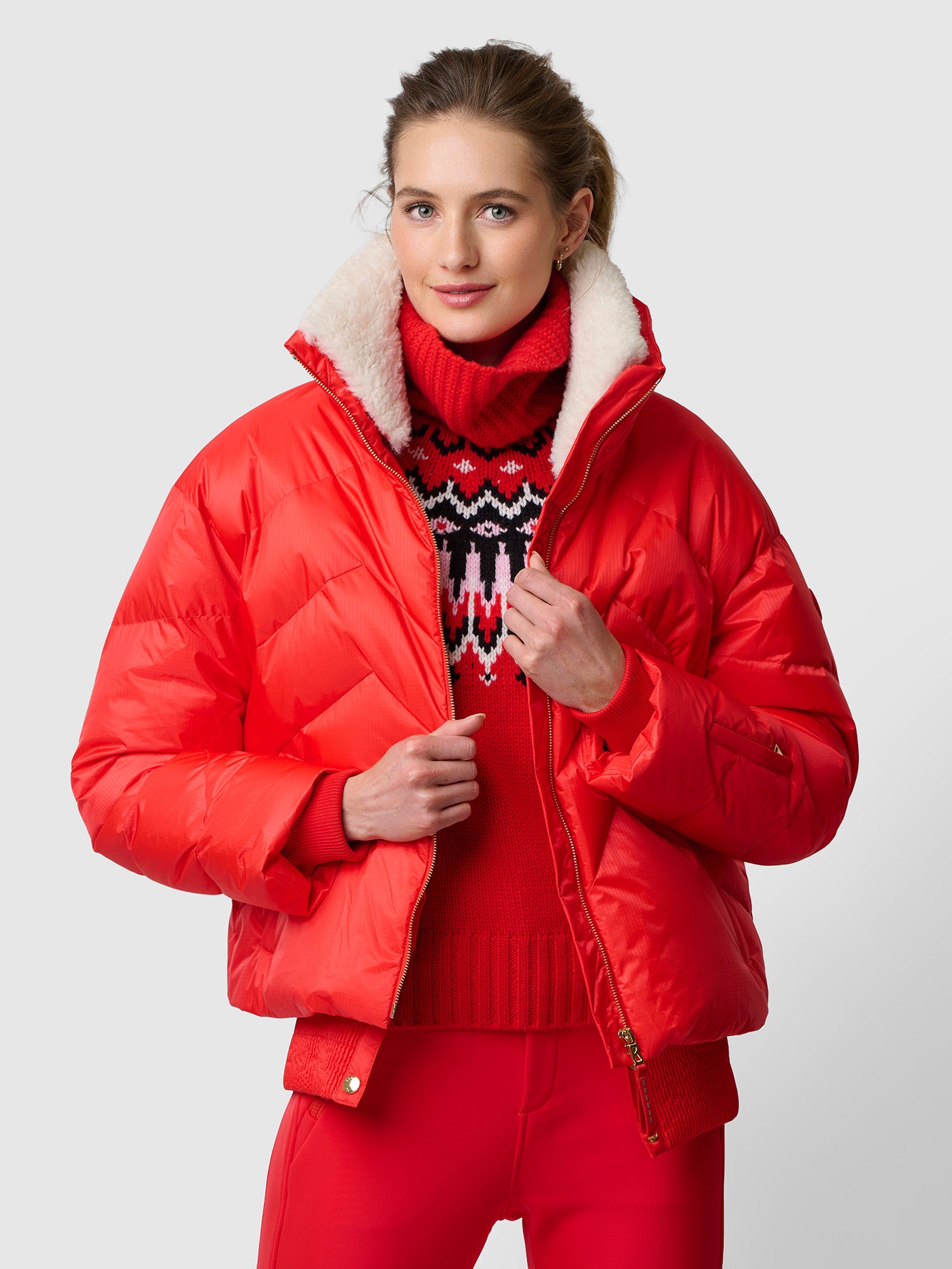 Woman in a cropped puffer with a matching knit co-ord set and sneakers, winter athleisure look