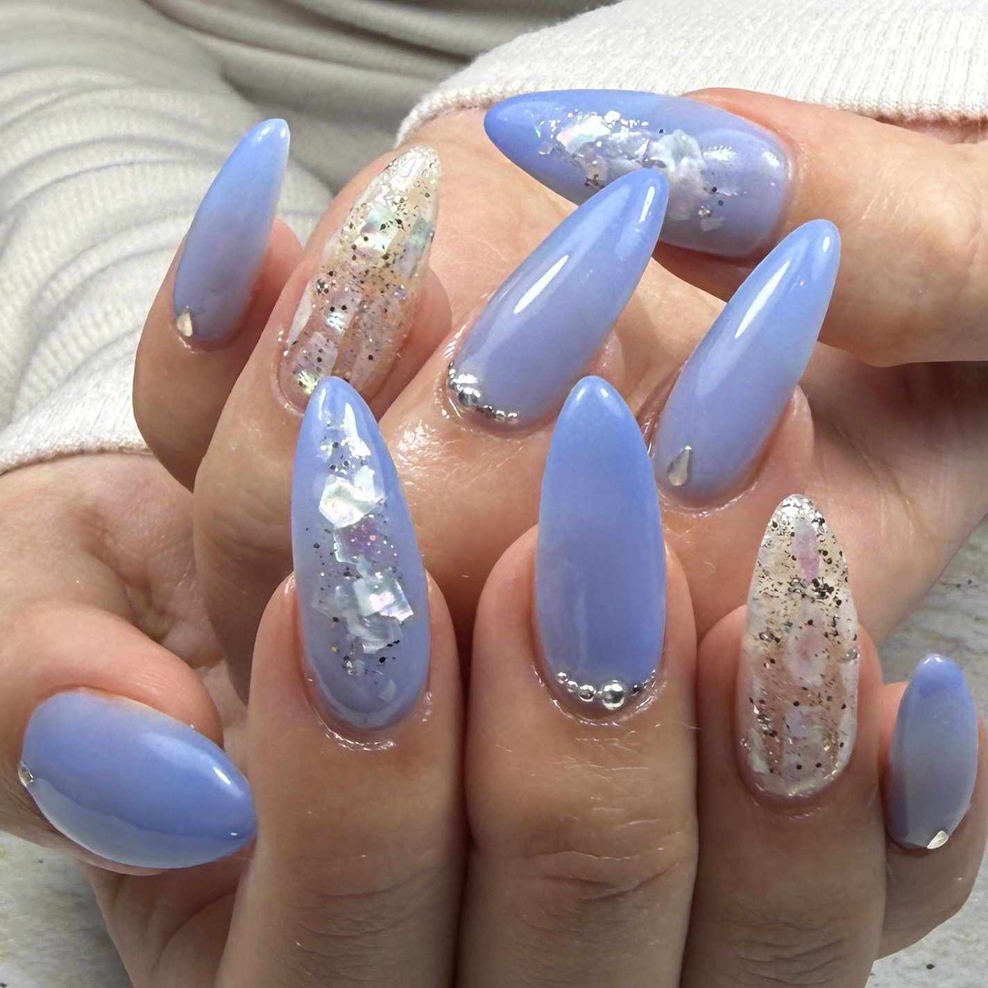 Soft periwinkle blue nails with silver glitter accents