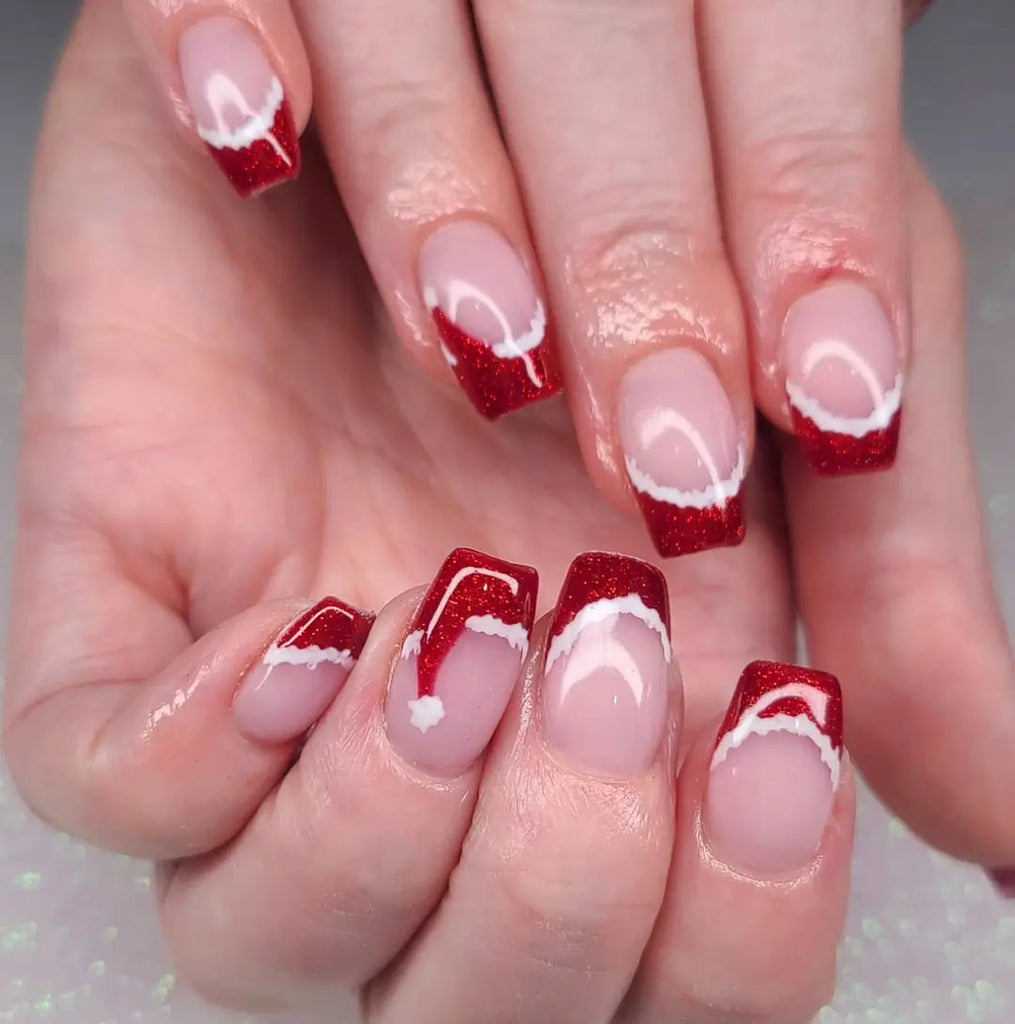 Sheer nude square nails with red glitter Santa-hat French tips and white trim