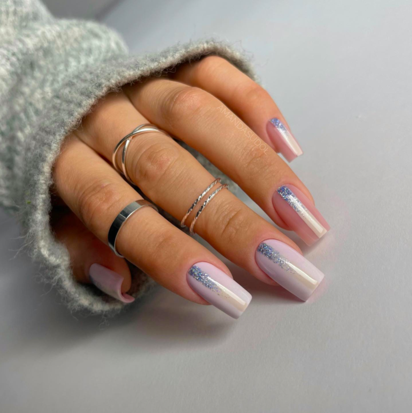 Nails with icy blue base fading into silver glitter at the tips