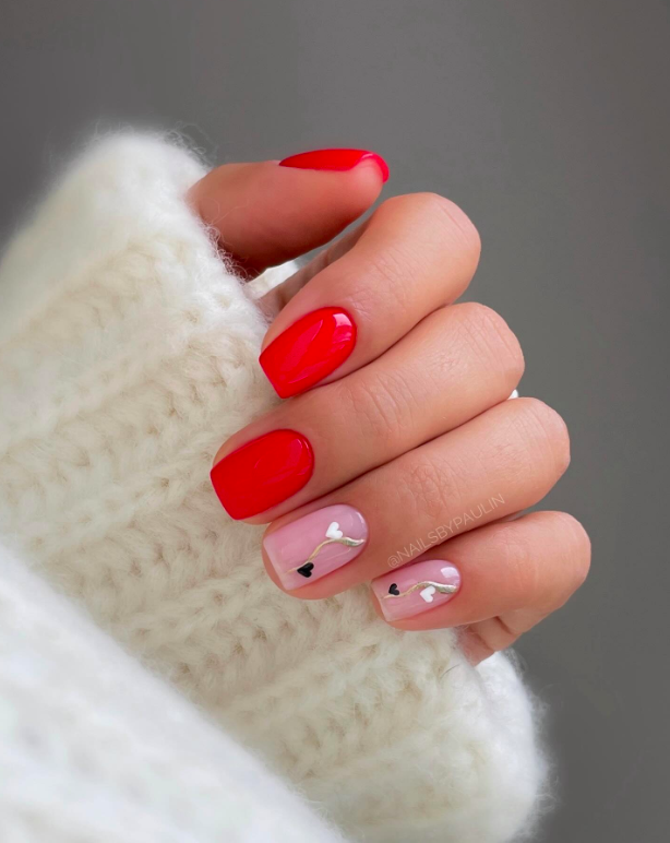 Red nails with small heart accent design