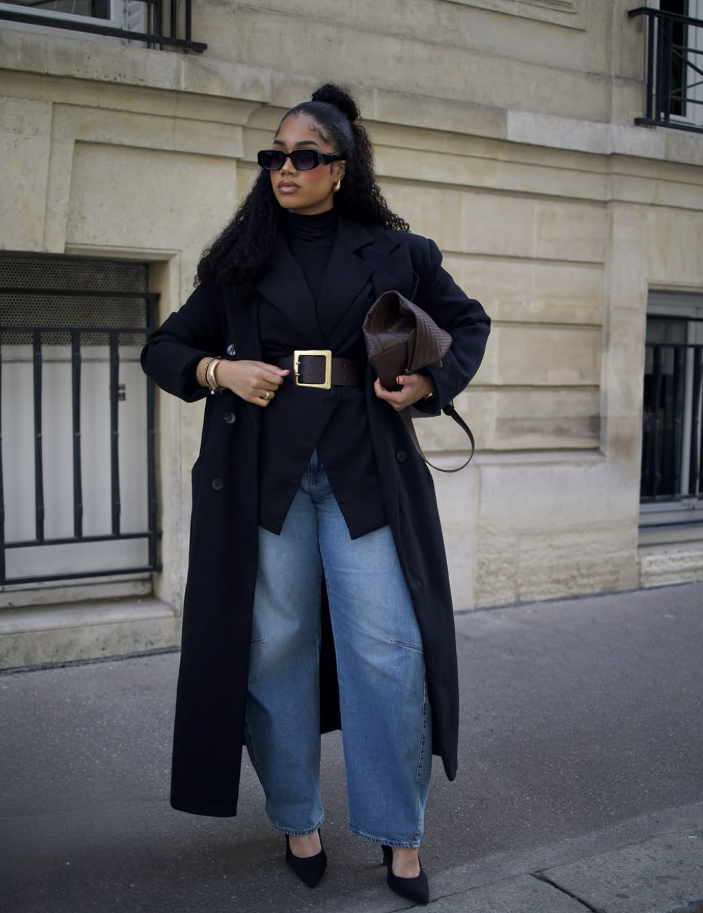 Belted black blazer under a long trench coat with barrel-leg jeans and pointed heels