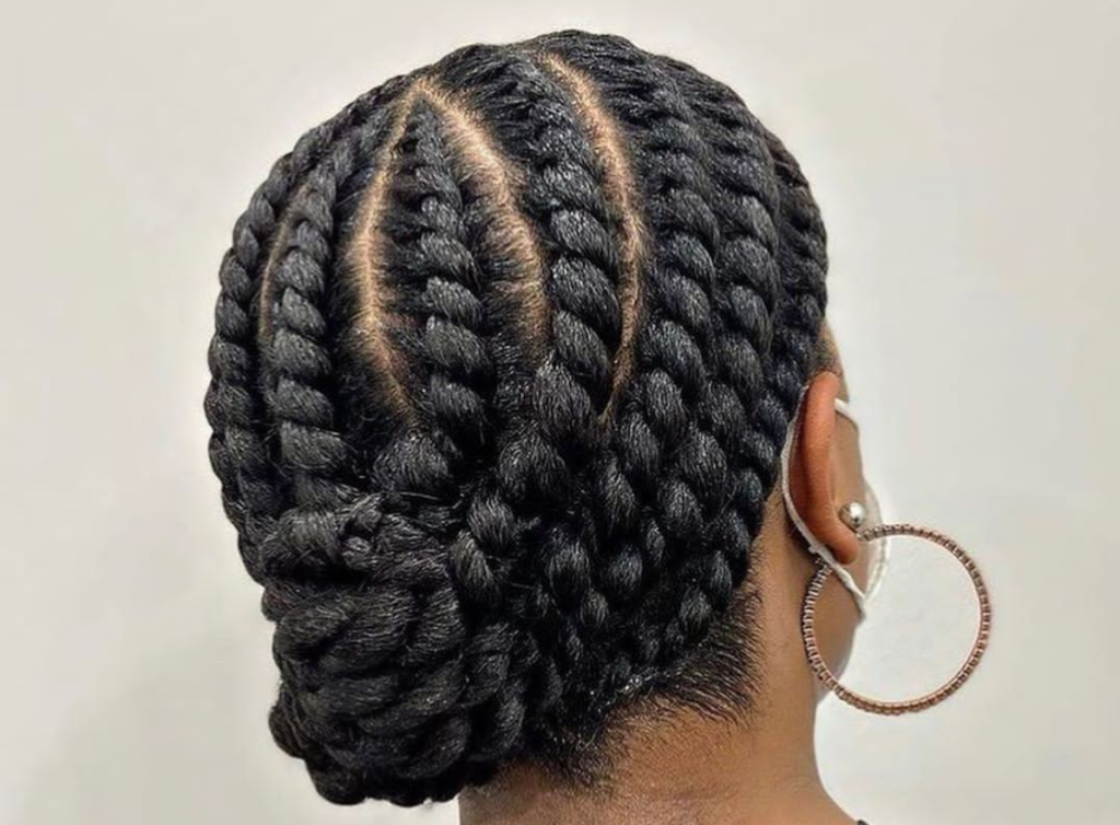 Flat twists along the crown feeding into a low curly puff
