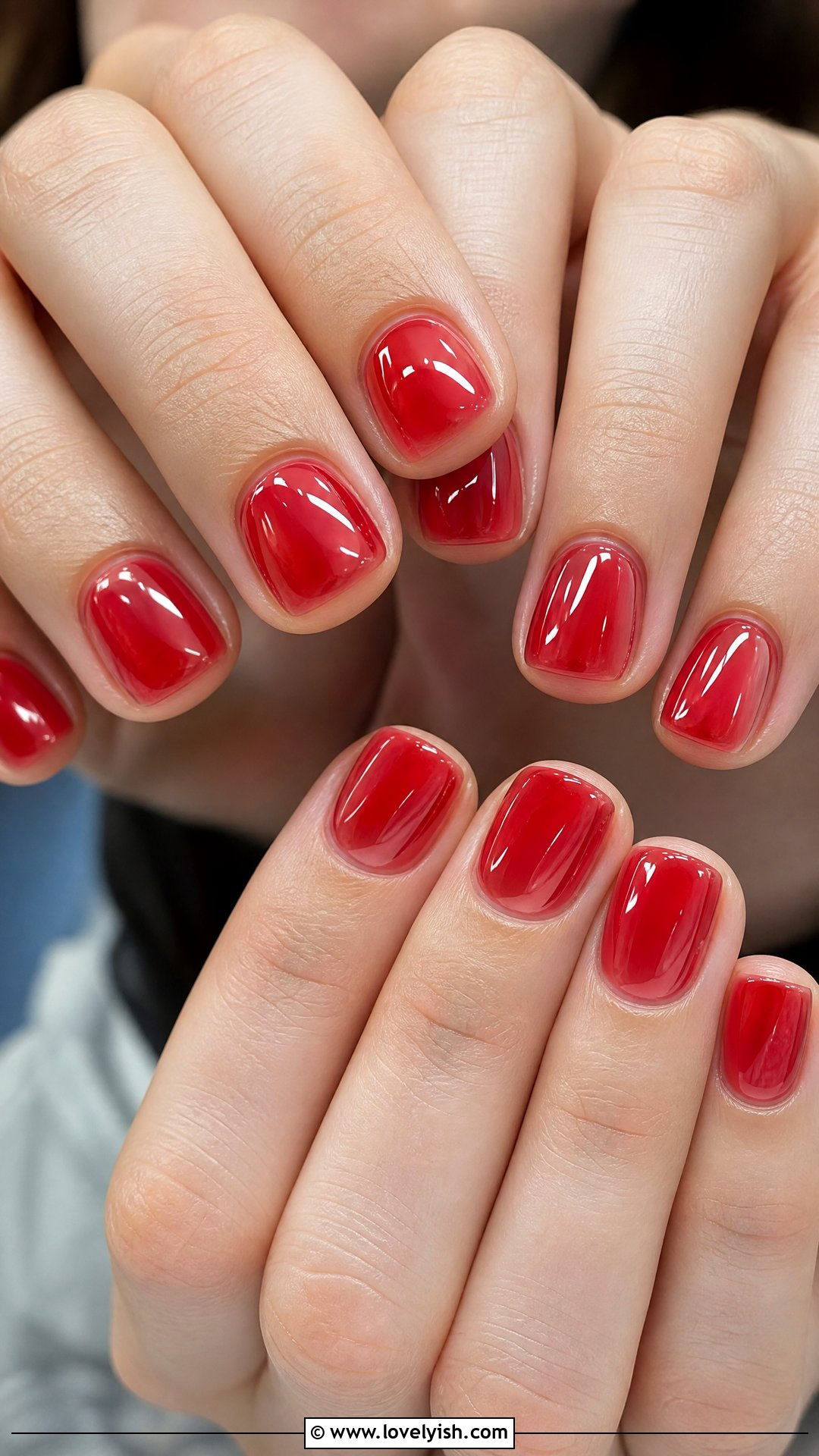 Short square nails with a sheer wash of cherry red jelly polish