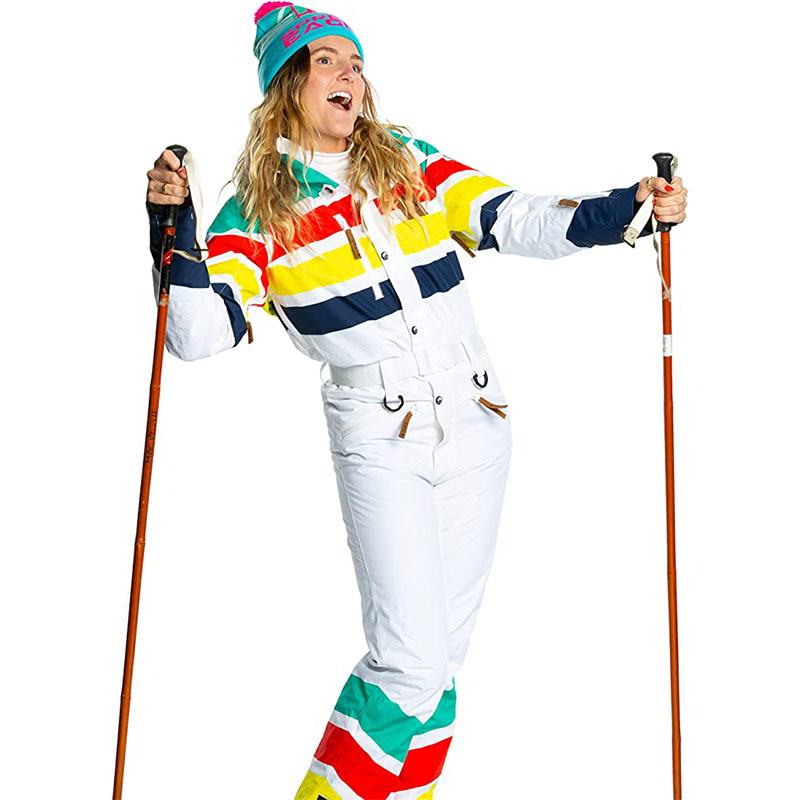 Woman in a retro white ski suit with colorful stripes holding ski poles