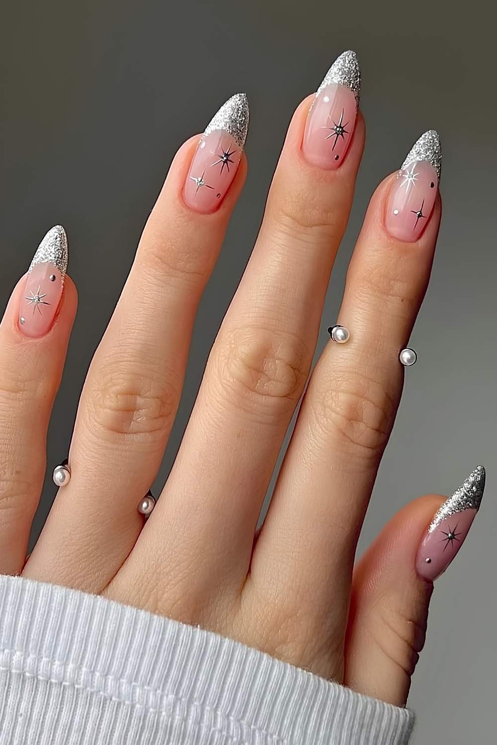 Nude nails with silver glitter French tips and small celestial nail art