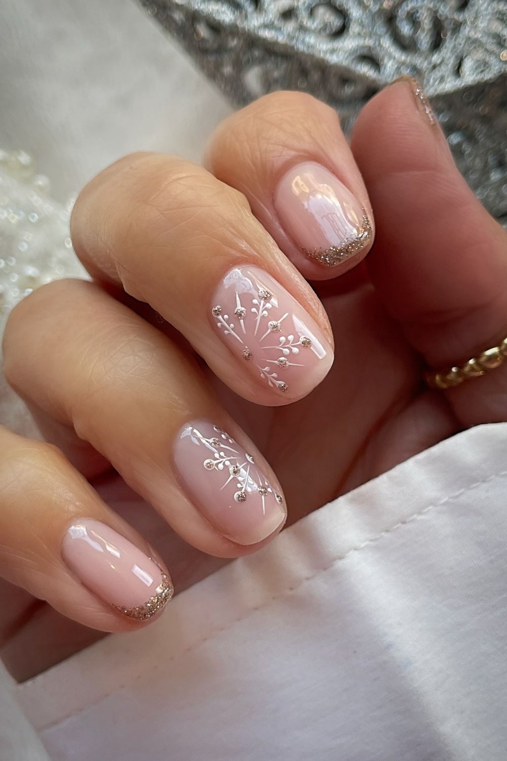 Champagne beige nails with delicate white snowflake art